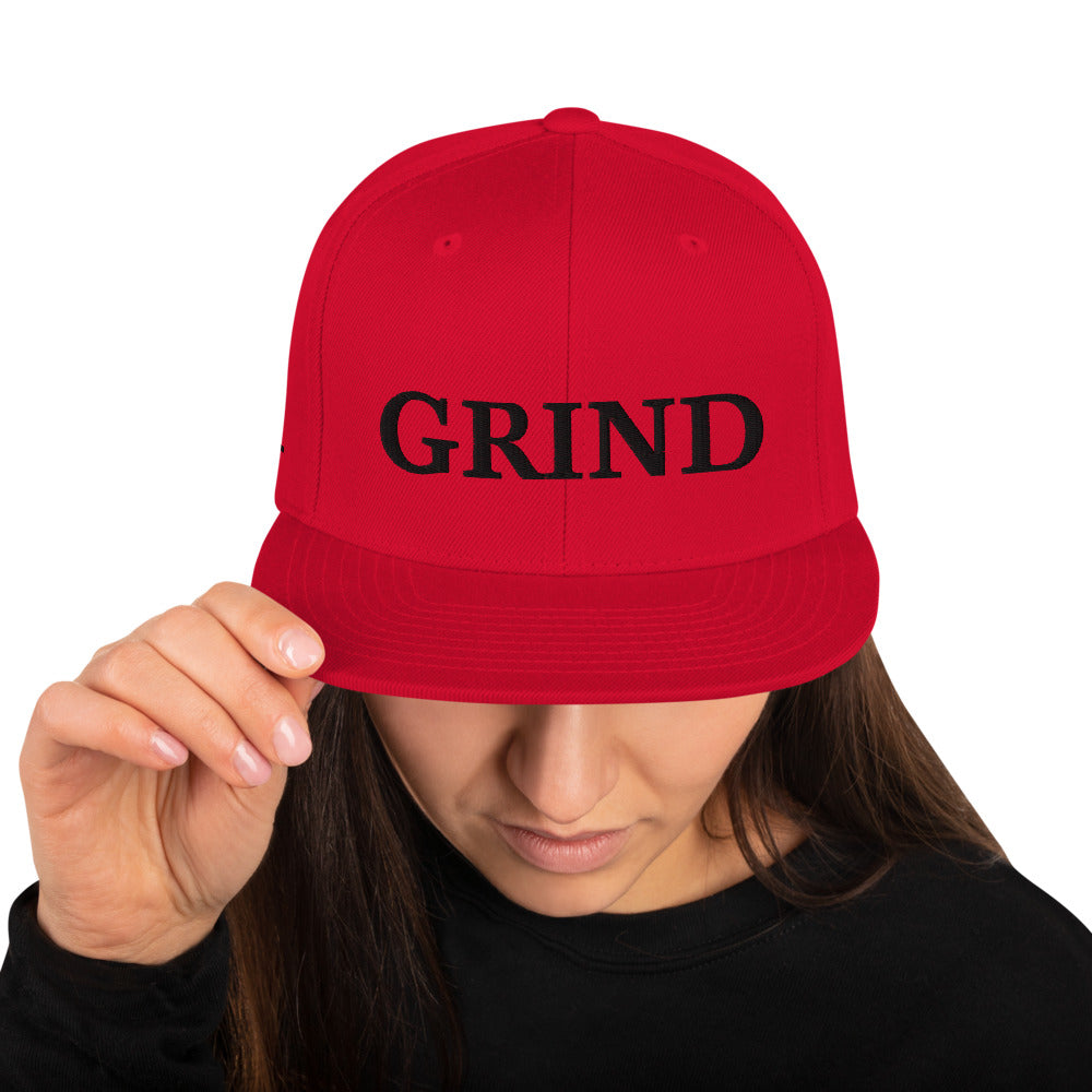 red "grind" snapback hat with black letters and black brim