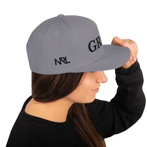 silver "grind" snapback hat with black letters 